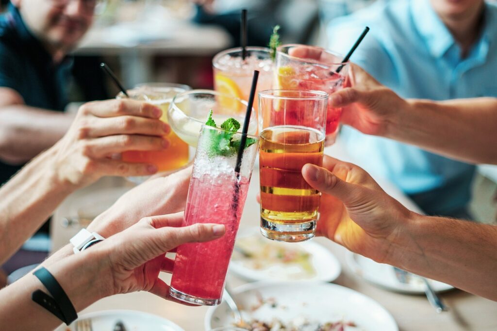 Gäste in einer Bar, die gemeinsam mit Cocktails anstoßen